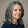52-year-old woman with greying mid-length oval face haircut showing vertical silhouette against neutral backdrop
